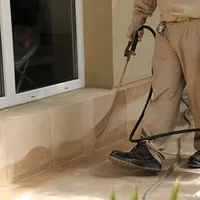 General pest control technician spraying exterior perimeter around a home in San Francisco, CA